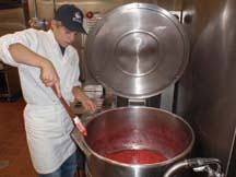 JAMMING: Jakob Zago stirs a concoction in a vat at the Brooks kitchen.